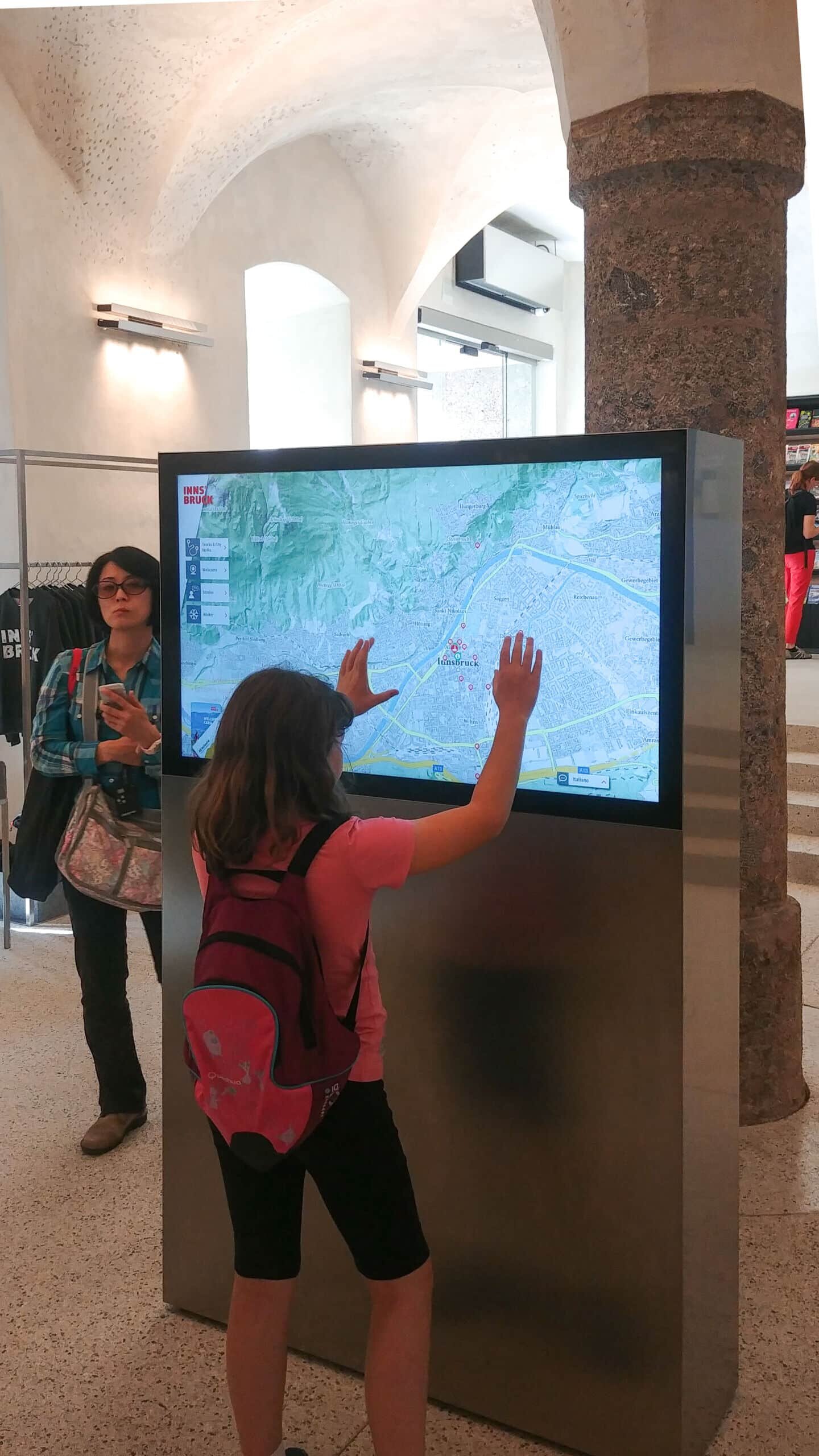 Besucher interagiert mit Karte auf Multitouch-Monitor in der Innsbruck Info