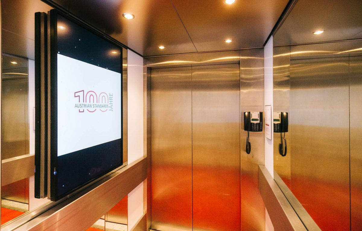Lifts with glazed screens presenting standards and animated information