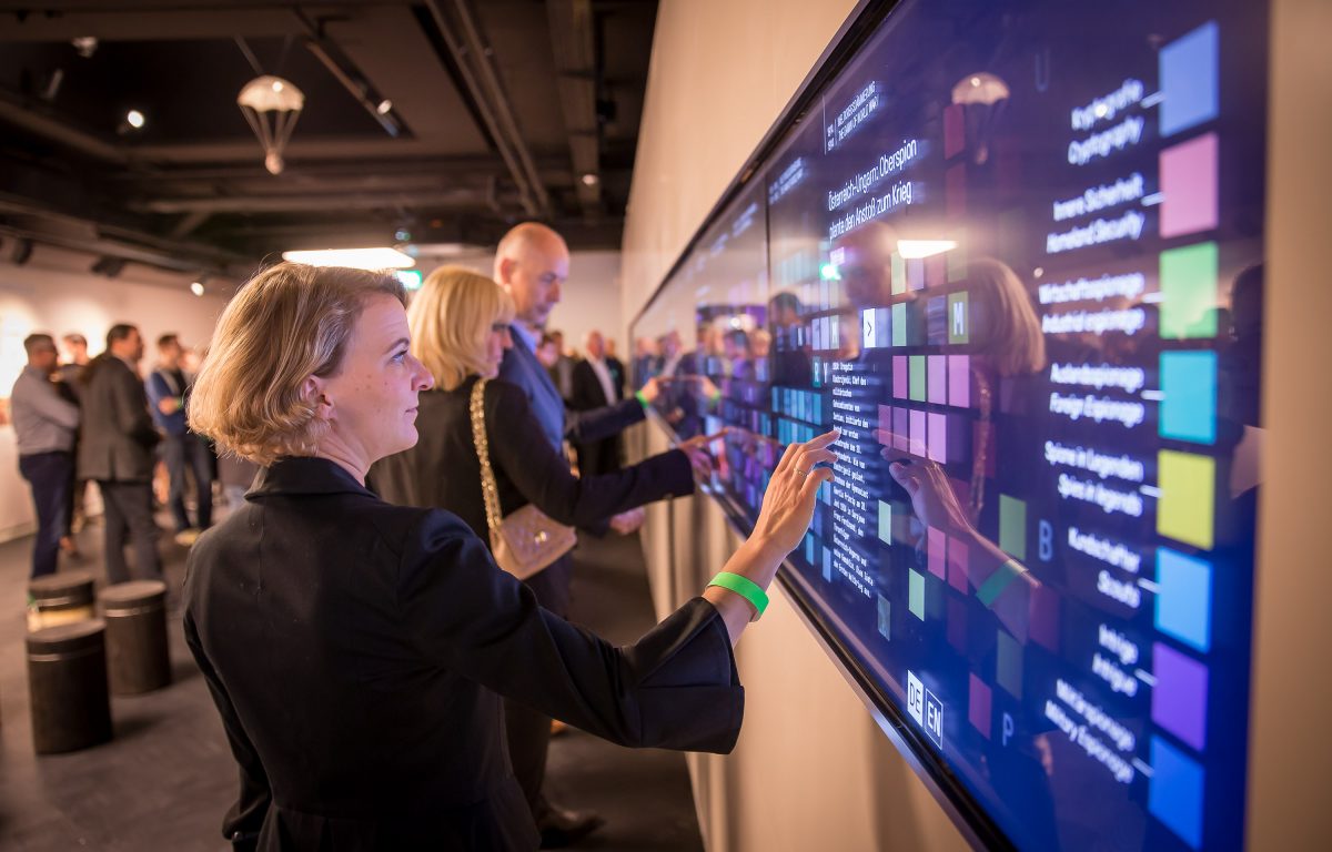 Visitors interact with large multi-touch wall in the German Spy Museum