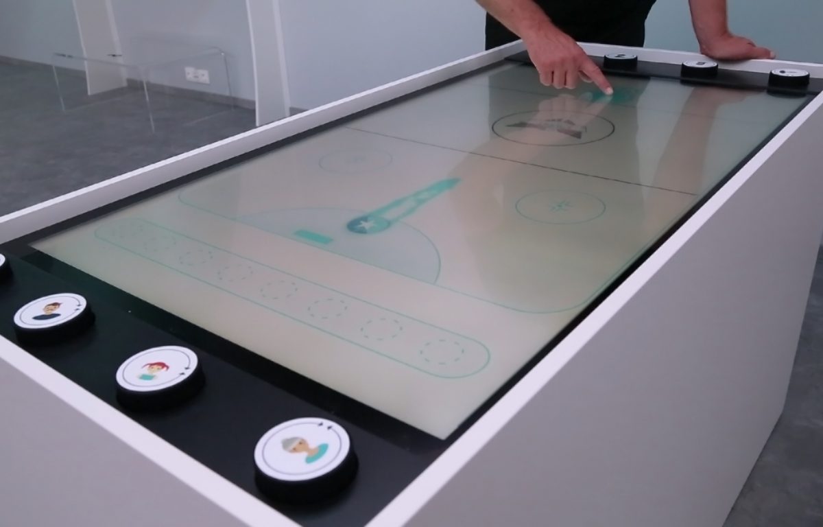 Multitouch table with air hockey game in experience store