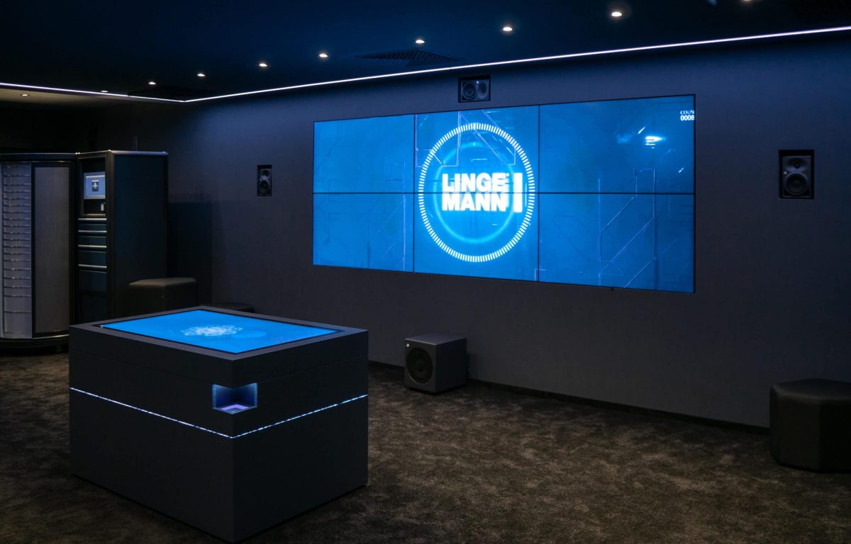 Lingemann Showroom mit Bildschirmwand und interaktivem Tisch zur Produktpräsentation