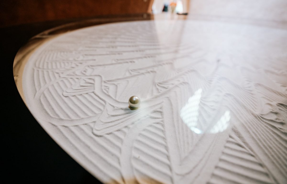 Steel ball draws circles and draws complex like beautiful patterns in the sand